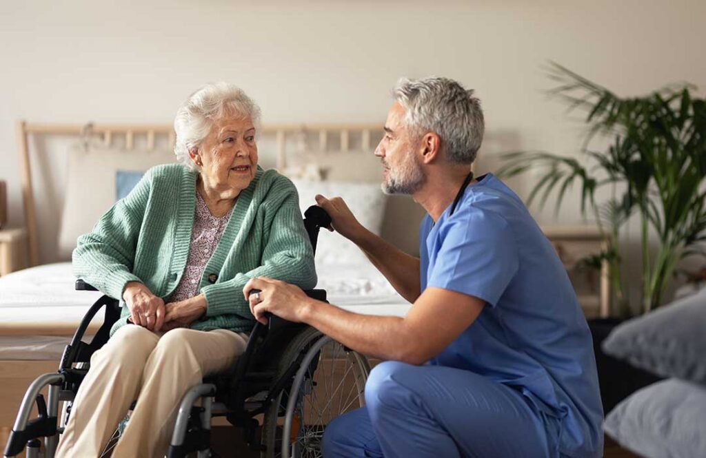 Resident speaking with an administrator at a quiet assisted living office while holding written notes.